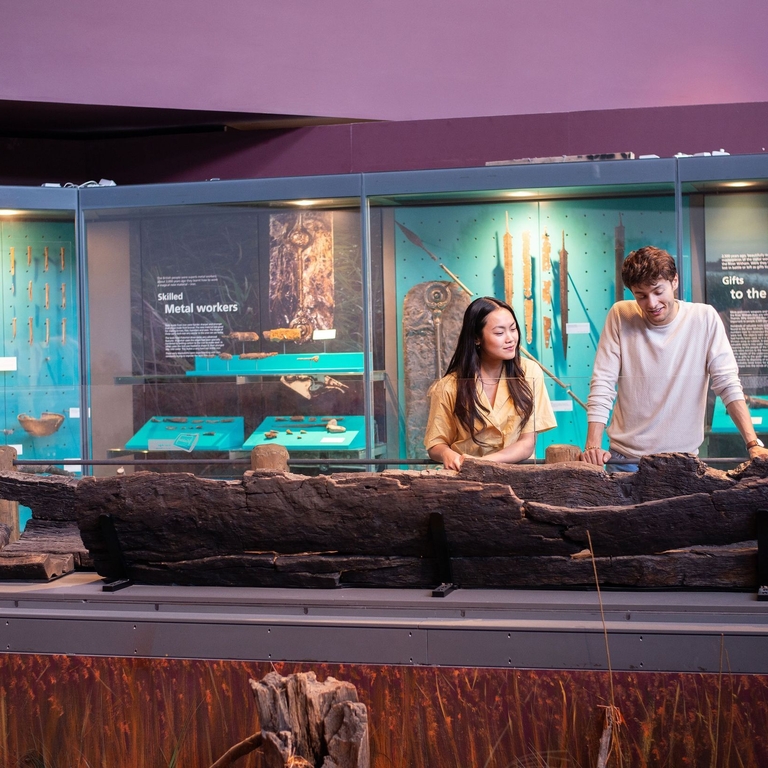 A man and a woman look at an exhibit in a museum