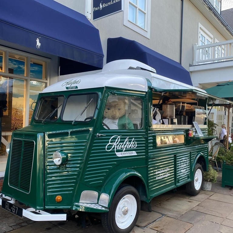 A green coloured vintage car promoting Bicester Village