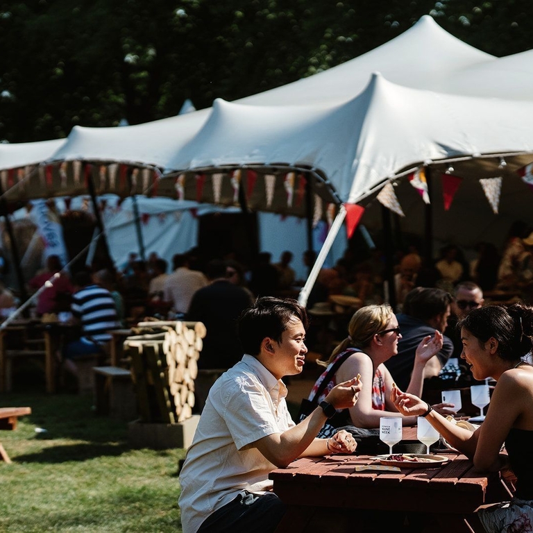 Groups of people sitting at tables and drinking wine at Norwich Wine Festival