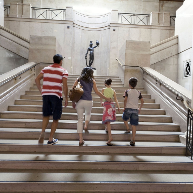 Family with two children climbing stairs in a museum
