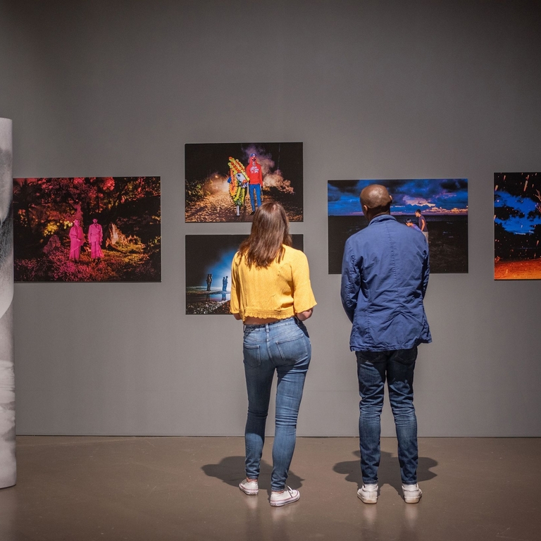 A woman and a man stand looking at an exhibition
