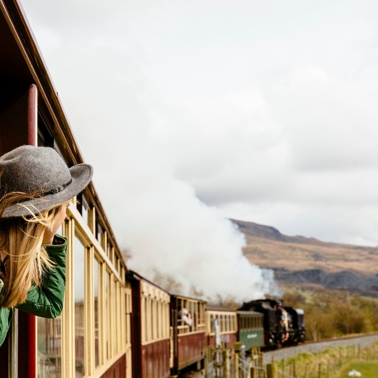 Woman looking out of window of traditional railway train