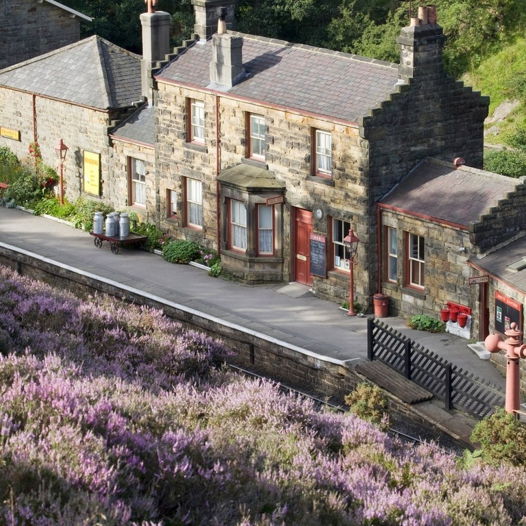 View from above of train station in village. Purple flowers