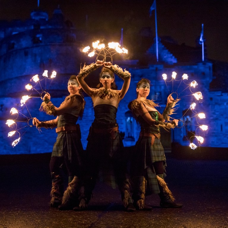 A procession of dancers with fire torches near North Bridge outside Edinburgh Castle