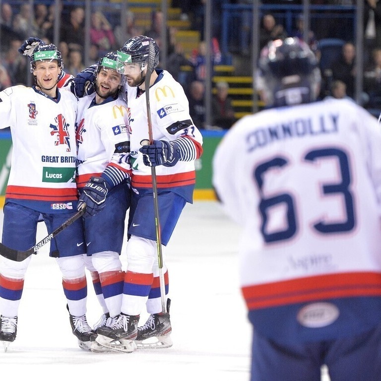 Group of three Great Britain ice hockey players celebrating on the ice together