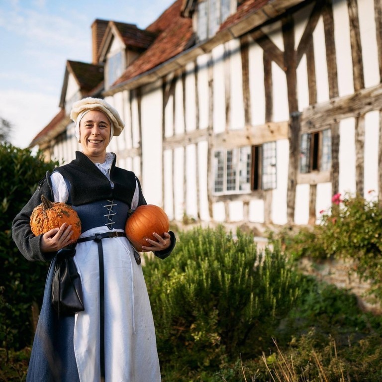 A lady standing outside Mary Arden's Farm