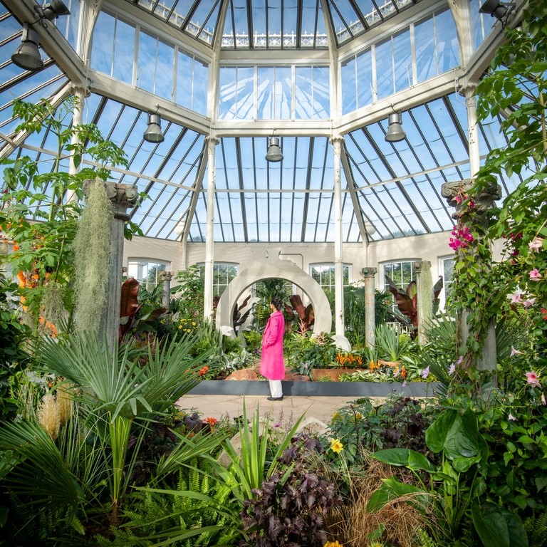 A visitor enjoys Surreal Pillars of Mexico, a horticultural display by Jon Wheatley at Kew Gardens