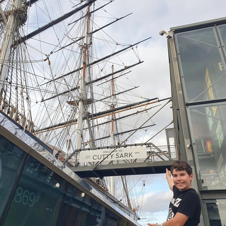 A child posing outside the Cutty Sark in Greenwich, London