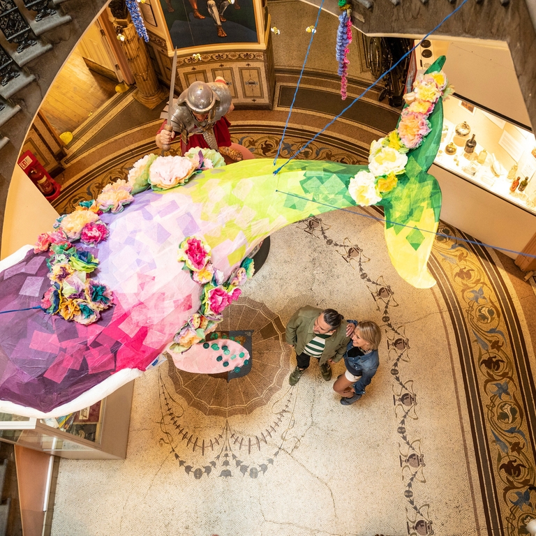 An art exhibit hanging above two people at the Grosvenor Museum in Chester
