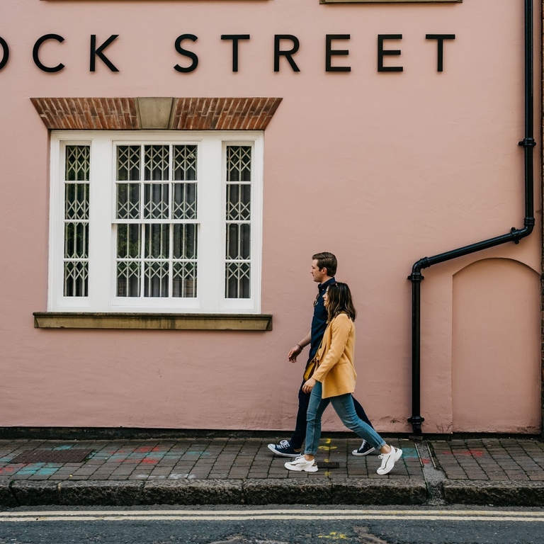 Two people walking in front of building