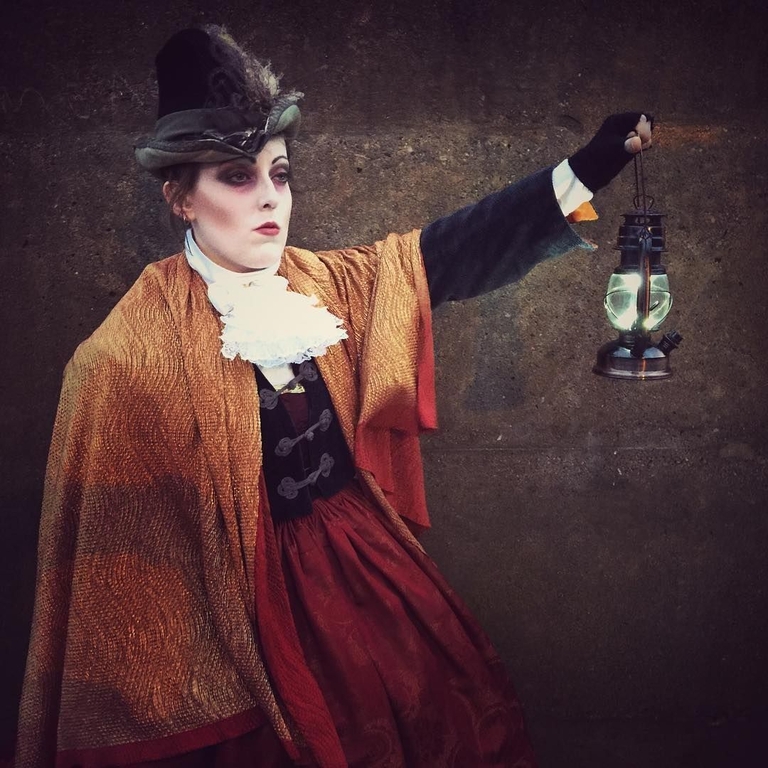 A lady holding a lantern on a ghost walk