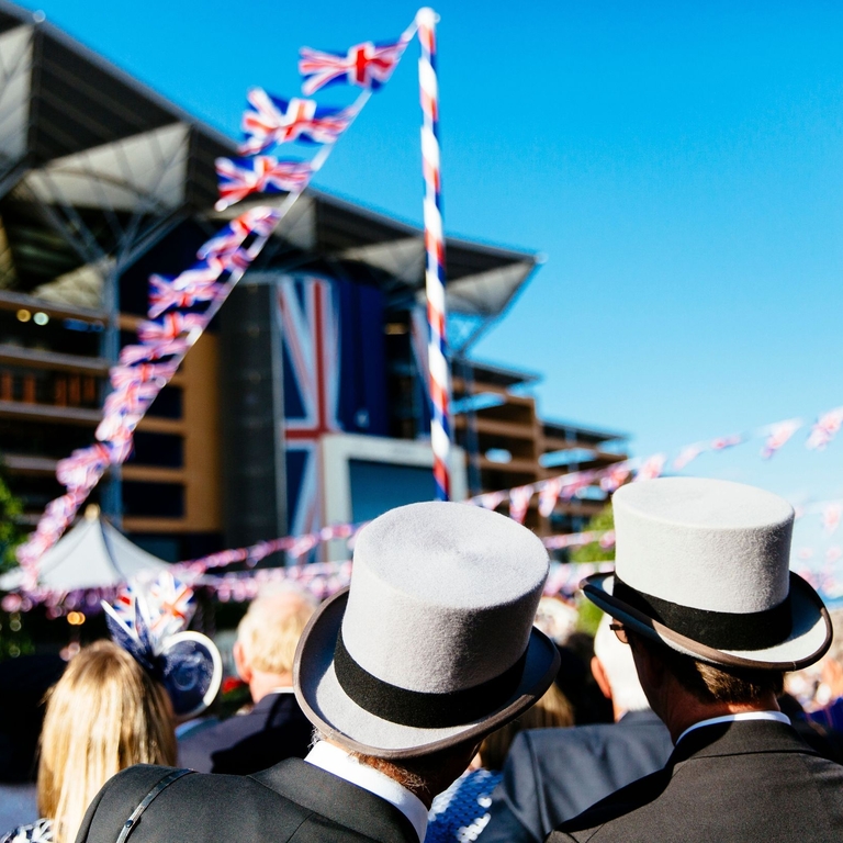 Rear view of two men wearing black suits and grey top hats