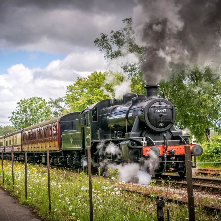A steam train moving down a track