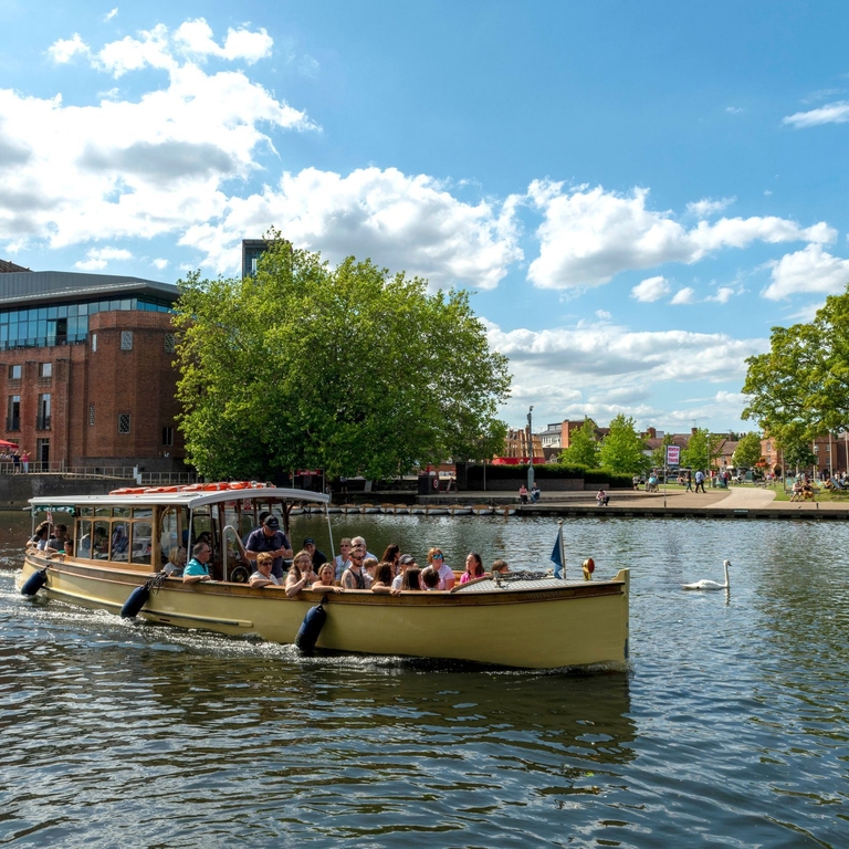 A boat sailing down the river Avon in Stratford-upon-Avon