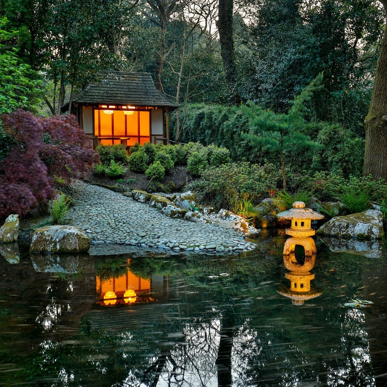 Lit up lanterns in a river at Pinetum Gardens in Cornwall