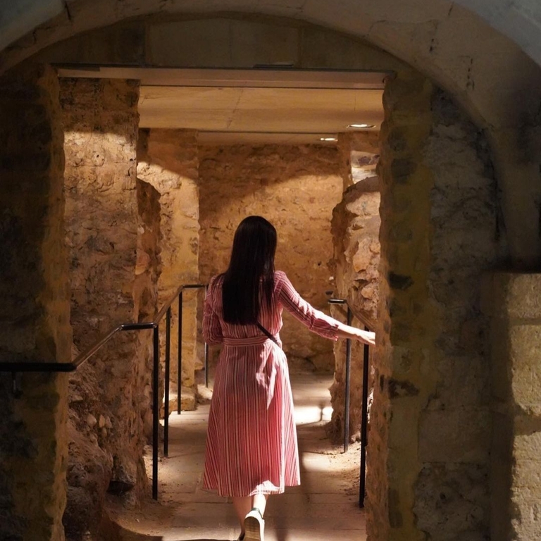 Woman exploring underground rooms at Oxford Castle