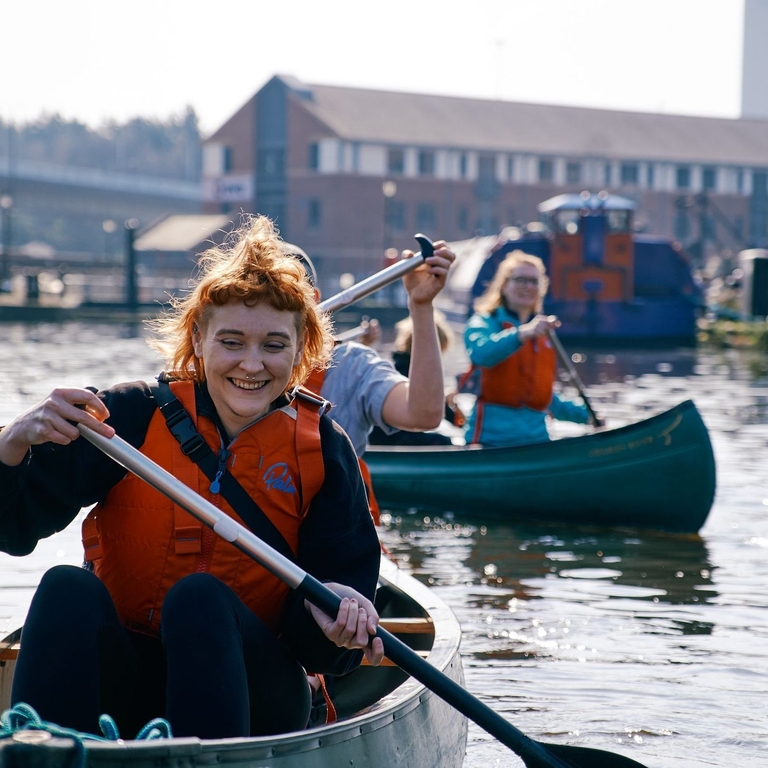 Three people rowing down the river Don in Sheffield