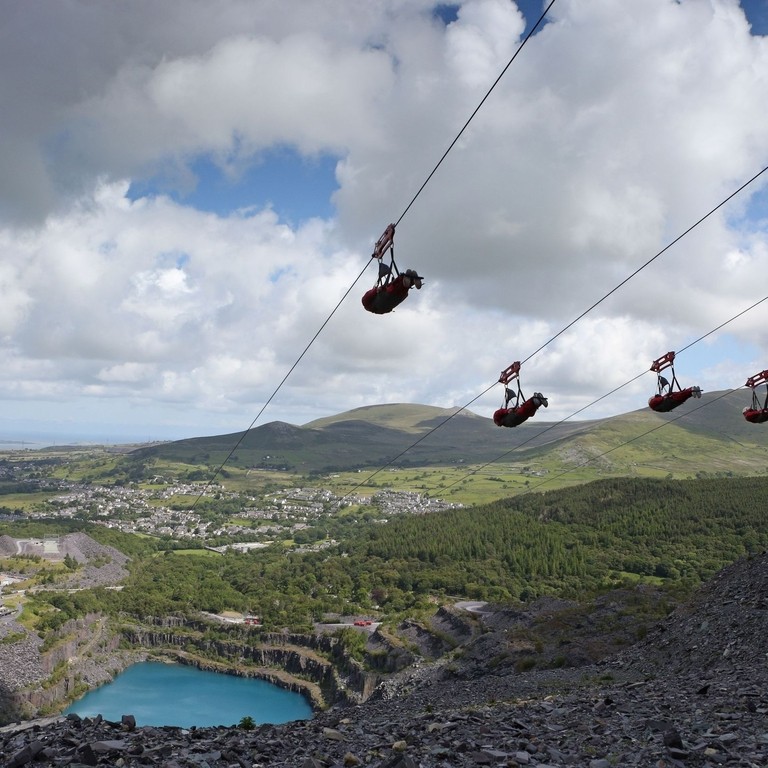 Persone che utilizzano le zipline sopra Penrhyn Quarry, vicino a Snowdonia, Galles