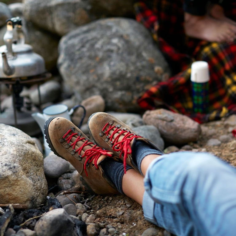 A person in boots, resting and waiting for kettle to boil