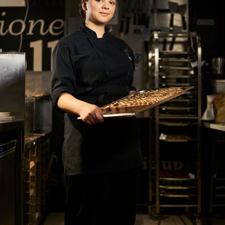 Woman presenting tray with chocolate truffles