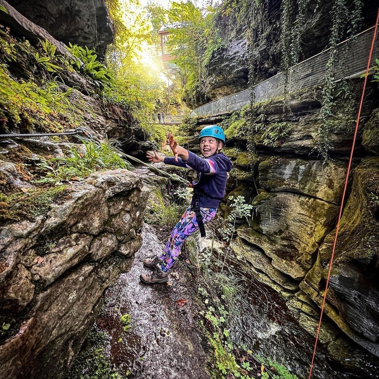 A child hanging from a rope while adventuring in the Yorkshire Dales.