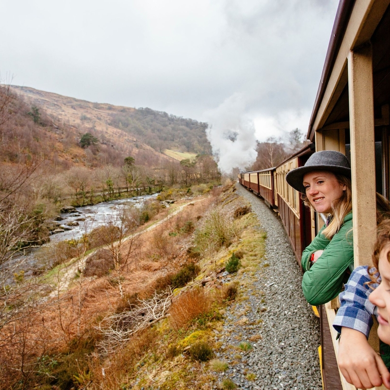 Woman and boy leaning out of window of steam train