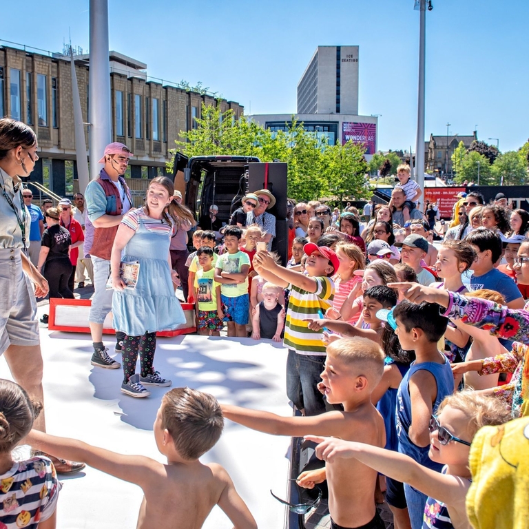 Performers on an outdoor stage at the Bradford Literature Festival