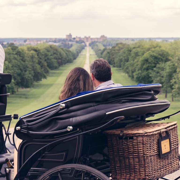 A couple in a carriage looking down the Long Walk in Windsor