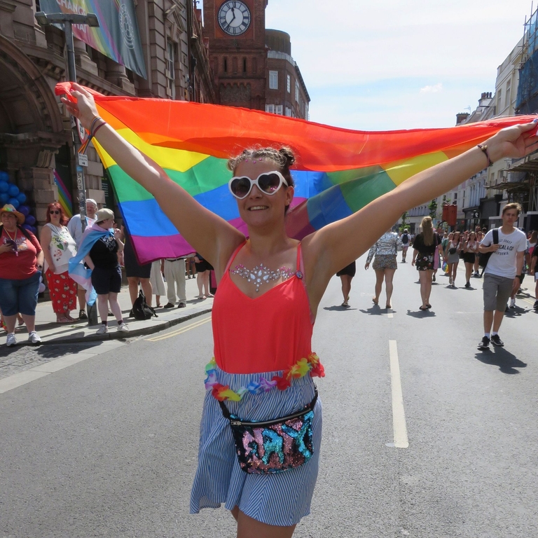 Woman flying rainbow flag during Pride