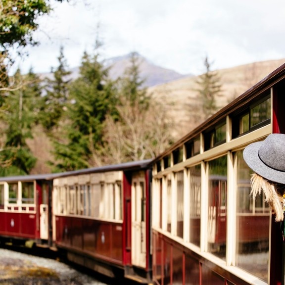 Woman leaning out of window of steam train
