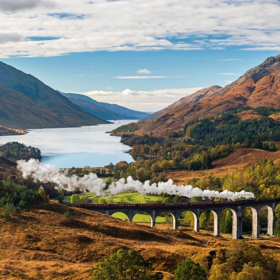 Vista della valle delle Highlands e del viadotto di Glenfinnan, treno a vapore sui binari, Loch Shiel sullo sfondo
