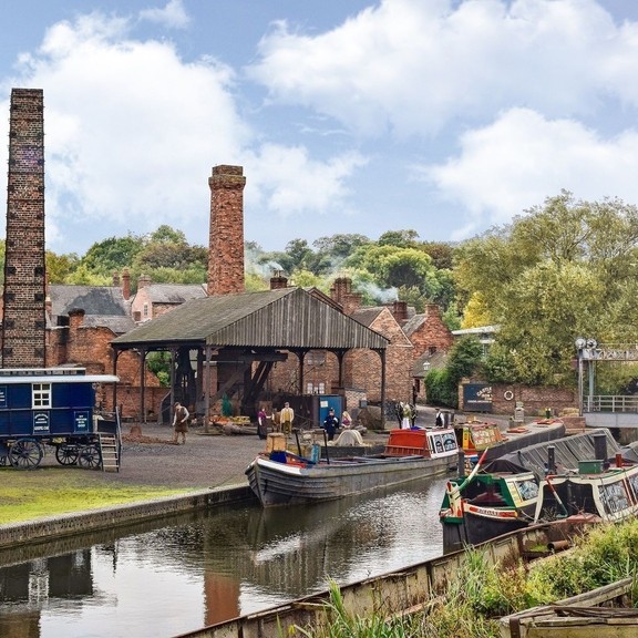 An outside view of the Black Country Living Museum with canal boats and workers dotted around