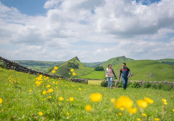 A man and a woman walk in open countryside