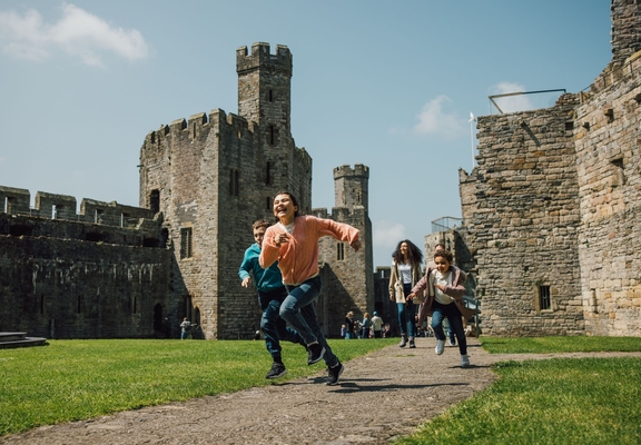 Kids running through the grounds of an old castle.