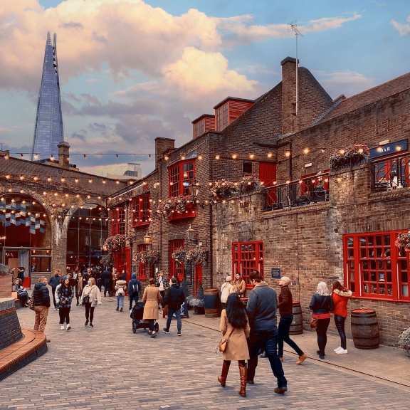 Des gens passant devant un pub, à Southwark, avec le bâtiment Shard au loin