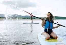 People paddle boarding in an estuary by the sea.