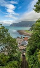 A steep railway heading down to a beach, overlooking an expansive pretty ocean.