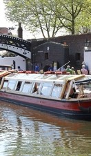 A barge sailing down a canal in Birmingham, near Sherborne Wharf