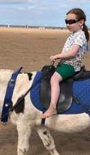 A child riding a donkey on Skegness Beach
