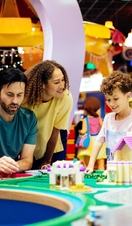 Mother, father and son laughing whilst playing with Lego