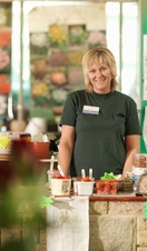 Female Garden Center Worker Behind Till