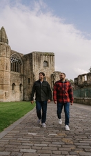 Two men walking by an Abbey Nave.