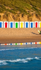 Idyllic Scene On Surfers Beach With Beautiful Beach Huts Reflecting In The Water