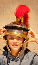 Boy wearing Roman centurion costume and helmet with feather