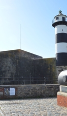 A lighthouse and cannon in the grounds of an old castle