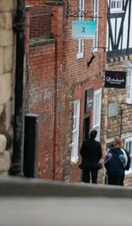 A woman and a man walk up a steep hill in a heritage City