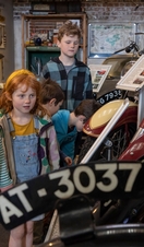 Children looking at a motorcycle exhibit at a transport museum.