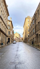 Looking up a deserted road, lined with Victorian stone buildings