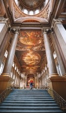 Man walking up a staircase. Painted night sky on ceiling