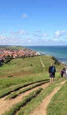 A group of people walking along the coast near Sheringham